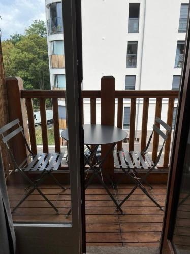 une table et deux chaises sur un balcon dans l'établissement Confortable studio, jolie terrasse a 350 m de Paris, à Gentilly