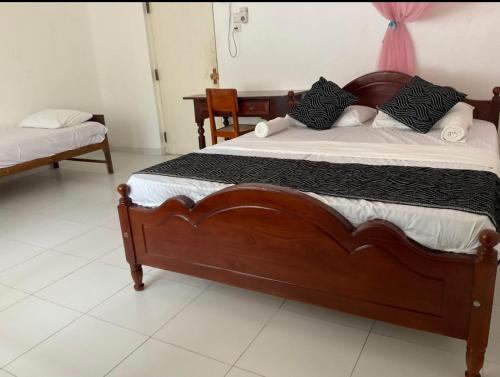 Cette chambre comprend un lit en bois. dans l'établissement Southern Breeze Homestay Weligama, à Walliwala East