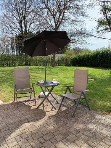 two chairs and a table with an umbrella at Eifel Holiday in Prüm