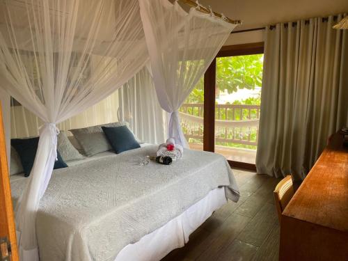 a bedroom with a white bed with a teddy bear on it at Solar Pitanga - Taipu de Fora in Barra Grande