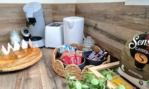 - une table avec des paniers de collations et une boîte de café dans l'établissement Caprices des vagues - A 300 m de la plage et à 4 kilomètres de Nausicaa, Place de parking privée, Eau douce, Netflix, Primes Vidéo, Wifi haut débit, à Le Portel