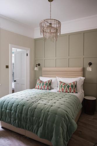 a bedroom with a large bed and a chandelier at Turret House in Crail