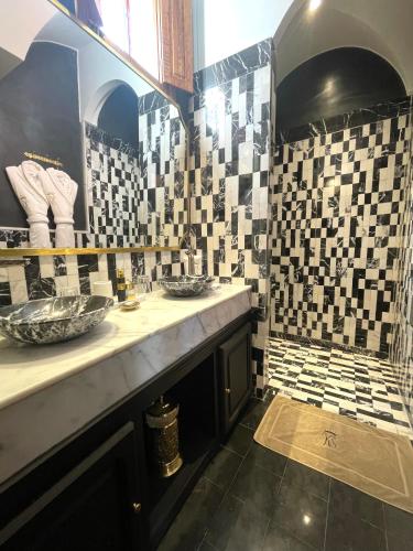 a bathroom with two sinks and tiles on the wall at Riad Ksar Al Amal & Spa in Marrakech