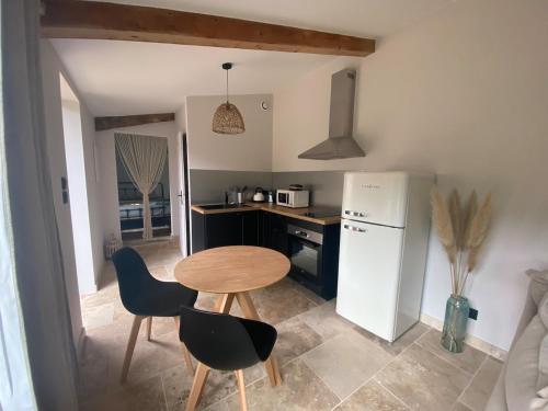 une petite cuisine avec une table et un réfrigérateur dans l'établissement Vacances face au Luberon, à Robion