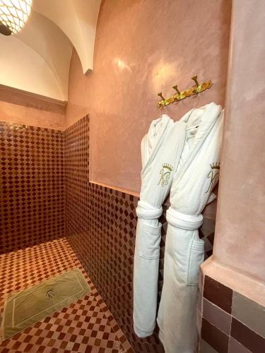 a bathroom with white towels hanging on a wall at Riad Ksar Al Amal & Spa in Marrakech