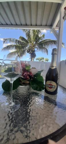 a table with a bottle of beer and a glass at Lakaz Dodo Apartment in Pointe aux Piments