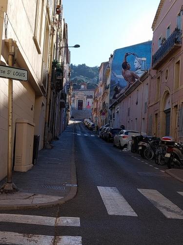 an empty city street with buildings and a bird on a billboard at Sète Centre ville T2 rénové in Sète