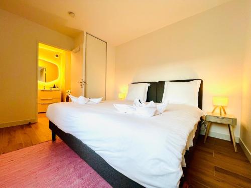 a large white bed with white pillows in a room at Cocon familial à 8min Disney avec Parking in Serris
