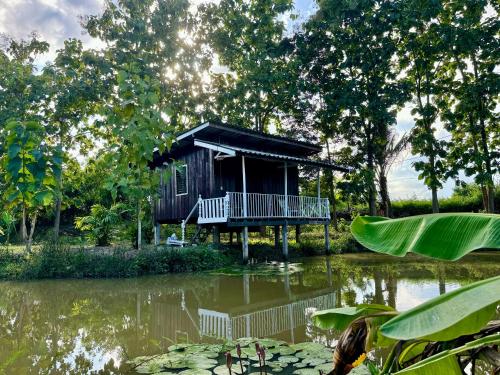 a house in the middle of a pond at บ้านสวนแม่แพร-Baan Suan Mae Pair in Mae Taeng
