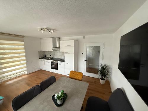 a living room with a table and a kitchen at Apart Alpenglow Imst in Imst