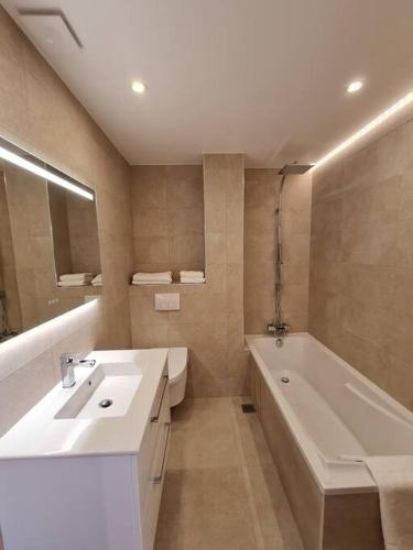 une salle de bain avec une baignoire et un lavabo et une baignoire dans l'établissement Superbe 3 pièces rénové au cœur du Cap d'Antibes, à Antibes