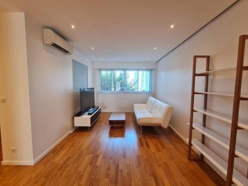 un salon avec un canapé et une télévision dans l'établissement Superbe 3 pièces rénové au cœur du Cap d'Antibes, à Antibes