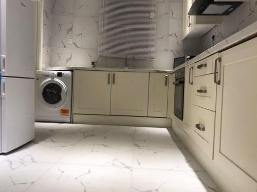 a white kitchen with a washer and dryer in it at Grandwest Apartment Ajah in Sangotedo