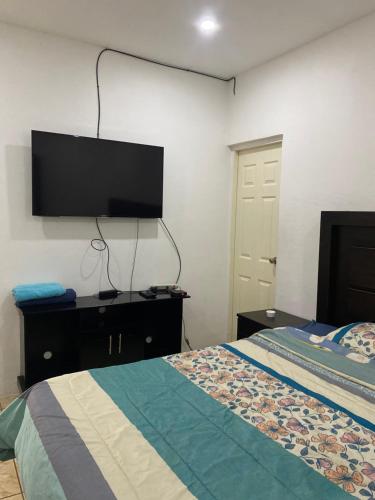 a bedroom with a bed and a flat screen tv at City break in Managua