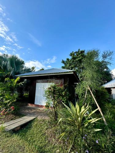 a small house with a white door in a yard at บ้านสวนแม่แพร-Baan Suan Mae Pair in Mae Taeng