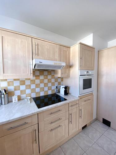 une cuisine avec des armoires en bois et un four à plaques de cuisson dans l'établissement Maison de vacances, à Bretignolles-sur-Mer