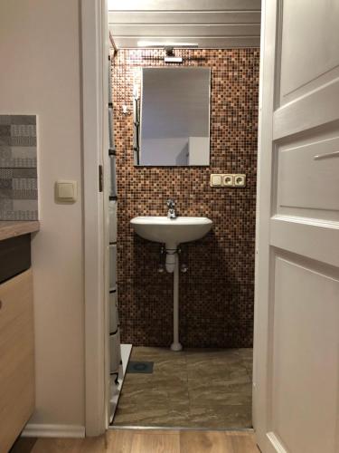 a bathroom with a sink and a mirror on the wall at Nameliai Suaugusiems, Sventojoje in Palanga