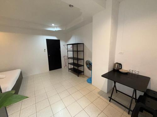 a room with a bed and a table and a toilet at Patong Canal Villa 101 in Patong Beach