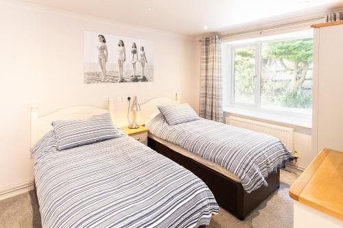 due letti in una stanza con finestra di Woolacombe Beach Retreat Apartments a Woolacombe