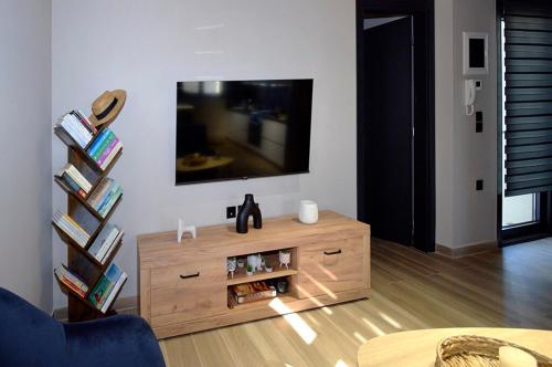 a living room with a television and a wooden entertainment center at Politis Luxury Home in Lamía