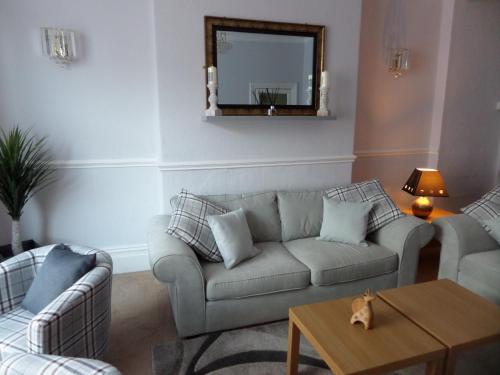 a living room with a couch and a mirror at Nathans in Blackpool