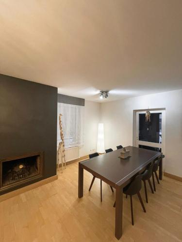 une salle à manger avec une table et des chaises et une cheminée dans l'établissement Magnifique Grand appartement Near Basel Parking privée, à Saint-Louis