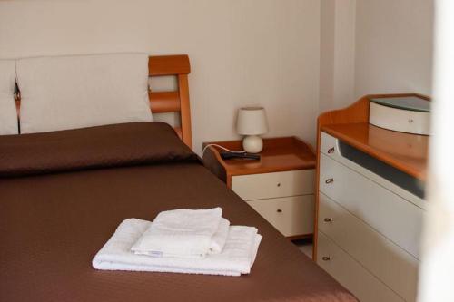 a bedroom with a bed with white towels on it at RiHome La Dimora del Rione Serra in Rogliano