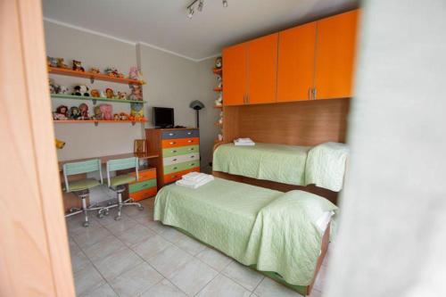 a bedroom with two beds and a desk at RiHome La Dimora del Rione Serra in Rogliano