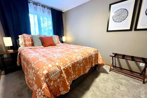 a bedroom with a bed with an orange bedspread and a window at Valley View Home with Game Room, & Exclusive Beach & Pool Access in New Rome