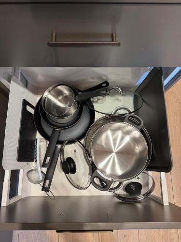 a bunch of pots and pans in a drawer at Apartament Centro 10 in Leszno