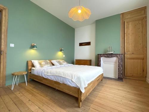 une chambre avec un grand lit et un lustre dans l'établissement Côte Ouest, à Fécamp