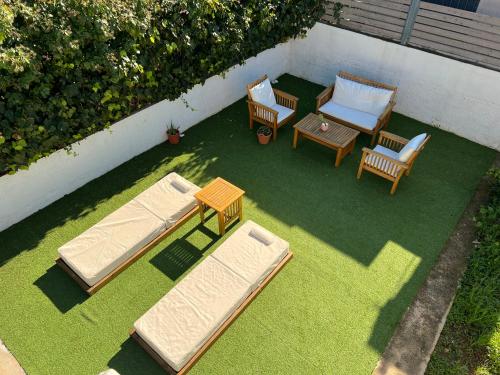 two beds and a table and chairs on the grass at Pool Villa Lagonisi 5min from Beach in Koropíon