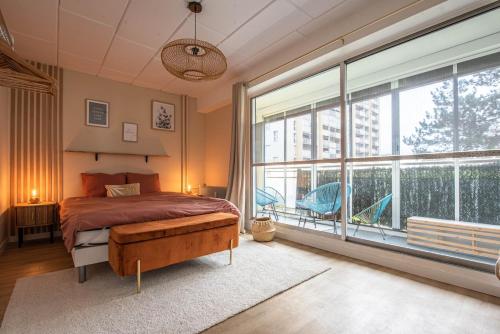 une chambre avec un lit et une grande fenêtre dans l'établissement Beautiful apartment in downtown Schuman, à Mulhouse