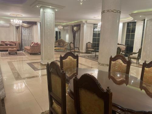 a large living room with chairs and a table at Luxury 3 bedrooms apartment for rent in a sheikh zayed compound in Kafr Abū ʼumaydah