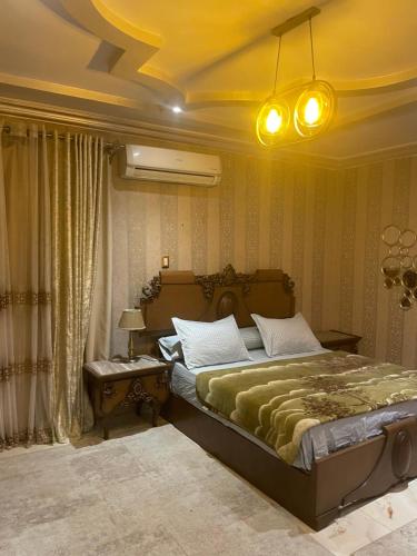 a bedroom with a large bed with a green blanket at Luxury 3 bedrooms apartment for rent in a sheikh zayed compound in Kafr Abū ʼumaydah