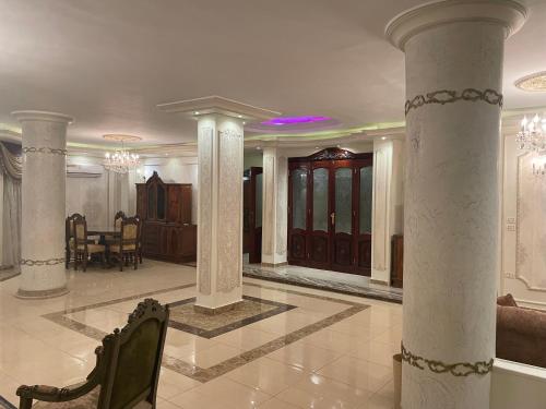 a lobby with columns and a table and chairs at Luxury 3 bedrooms apartment for rent in a sheikh zayed compound in Kafr Abū ʼumaydah