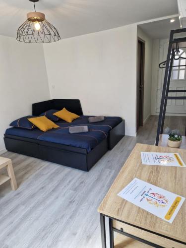 a living room with a couch and a table at Faubourg des voyageurs 4 - Studio climatisé 2 personnes - proche axe autoroute in Saran