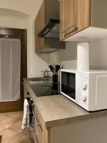 a kitchen with a white microwave on a counter at GolfHouseApartment in Bocenago