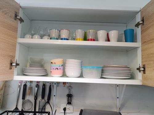 a kitchen cabinet filled with dishes and plates at "comodidad, seguridad y cercano a todo" in Los Paredones
