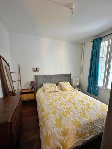 - une chambre avec un lit et une couette jaune et blanche dans l'établissement Chambre Privée - Gentilly - France, à Gentilly