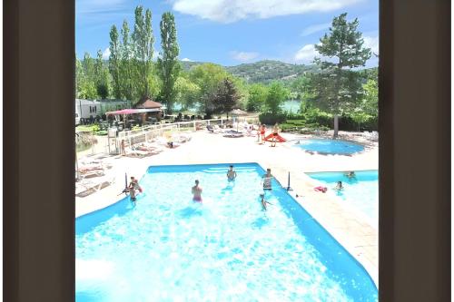 un groupe de personnes dans l'eau d'une piscine dans l'établissement Bungalow confortable près de Condrieu avec piscine partagée, à Condrieu