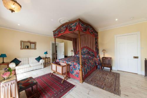 a bedroom with a canopy bed and a couch at Prince Hill House in Devizes