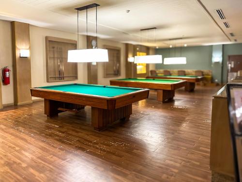 two pool tables in a room with couches at Yugen Suites at Pico De Loro in Nasugbu