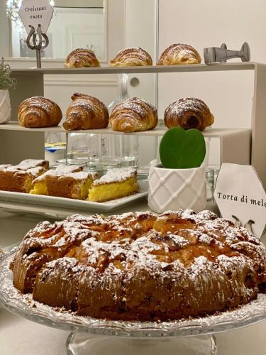 a cake on a plate on a table with other pastries at Boutique Hotel San Giovanni in San Giovanni in Persiceto
