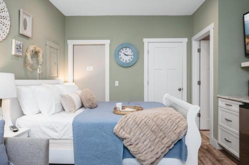 a bedroom with a white bed and a clock on the wall at Primrose Studio 1BR Studio near Downtown Beaches Wineries in Traverse City