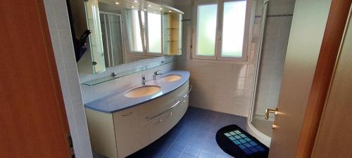 a bathroom with two sinks and a mirror at Casa Diana Ticino in Cugnasco
