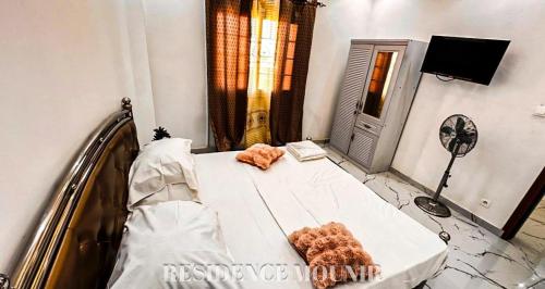 a bedroom with a bed in a room at Résidence Mounir in Thiès