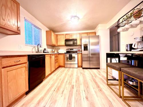 a kitchen with wooden cabinets and stainless steel appliances at Family Fun! 5 King Beds-Hot Tub-Fire Pit-Ski-Hike in Sandy