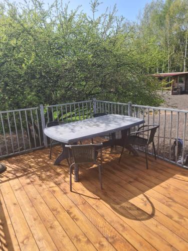 a picnic table on a deck with a fence at Camping Sonov apartment in Šonov