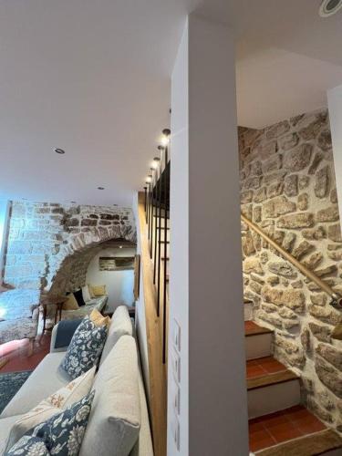 Cette chambre dispose d'un canapé et d'un mur en pierre. dans l'établissement Authentic Maison in Old Town, à Forcalquier